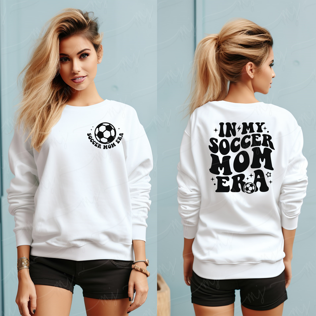 a woman wearing a white sweatshirt with the words in my soccer mom era on it